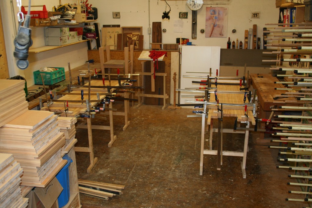 Holzwerkstatt mit Zwingen und vorbereiteten Holzteilen für Bettbau