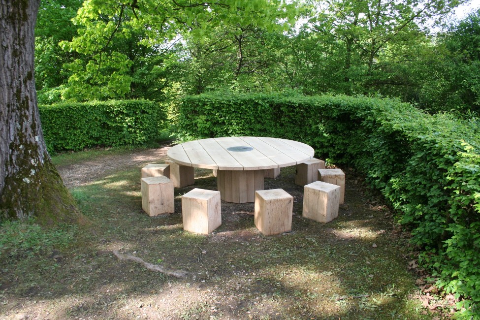 Runder Holztisch mit Hockern im Garten